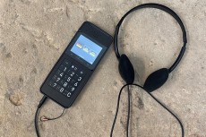 Auf einer Mauer liegt ein Audioguidegerät.