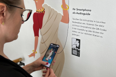 Eine Frau scannt einen QR Code mit ihrem Handy.