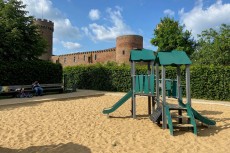 Ein Spielplatz, im Hintergrund eine Burg.